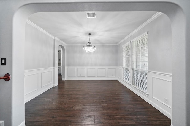 unfurnished dining area with dark hardwood / wood-style flooring, ornamental molding, and a chandelier