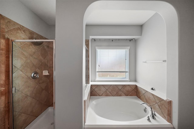 bathroom featuring shower with separate bathtub