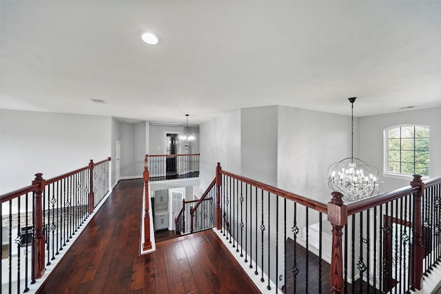 hall with a notable chandelier and dark hardwood / wood-style floors