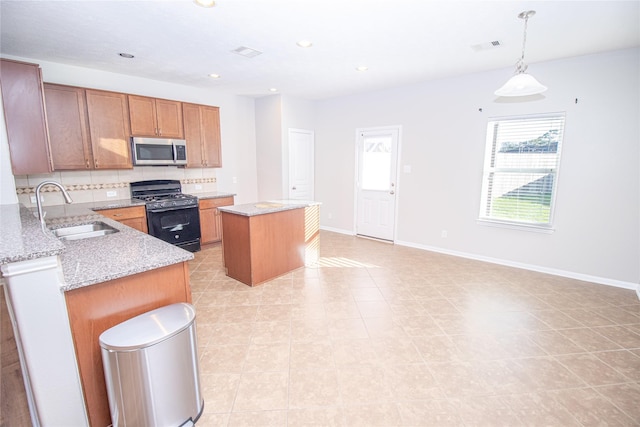 kitchen with a center island, sink, backsplash, black range with gas cooktop, and decorative light fixtures