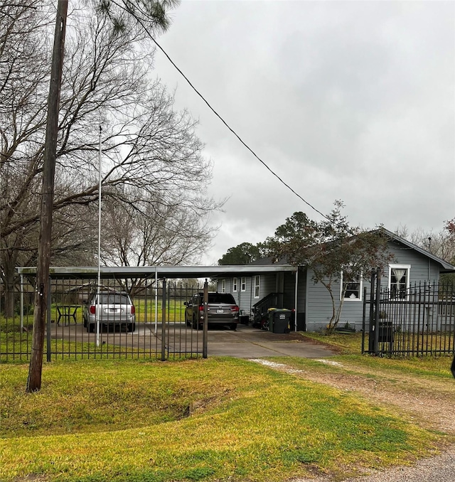 view of front of home featuring driveway, a carport, a front yard, and fence