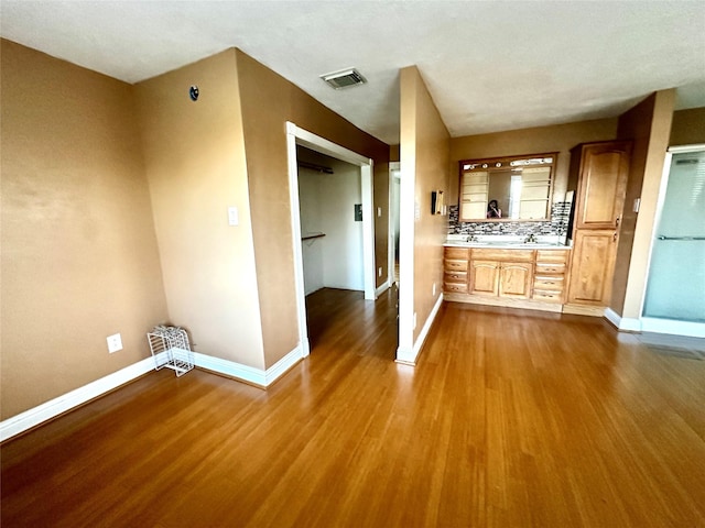 bathroom featuring baseboards, visible vents, wood finished floors, and vanity