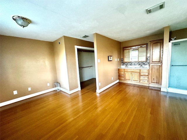 interior space with dark wood-style flooring, visible vents, and baseboards