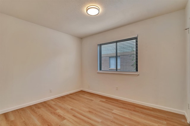 empty room featuring a textured ceiling and light hardwood / wood-style floors