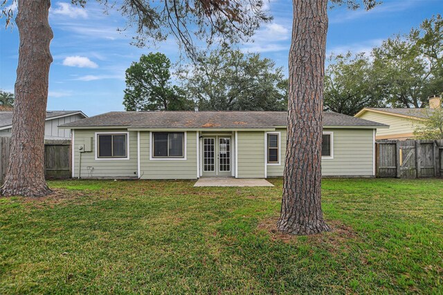 back of property with a patio area, a yard, and french doors