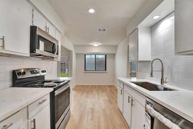 kitchen featuring light hardwood / wood-style floors, sink, white cabinetry, and stainless steel appliances