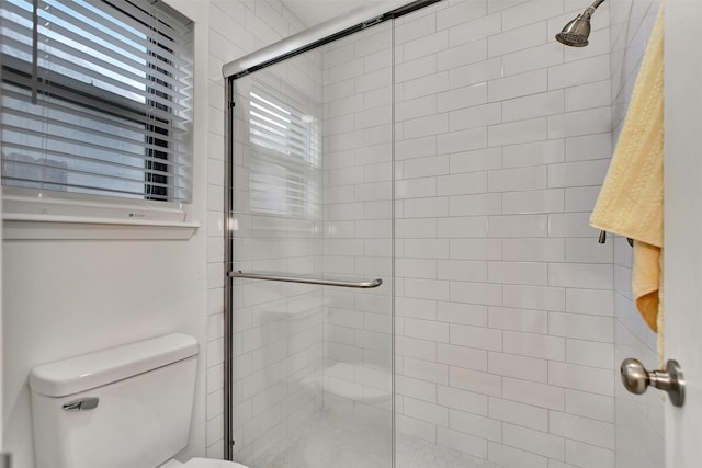 bathroom featuring toilet and an enclosed shower