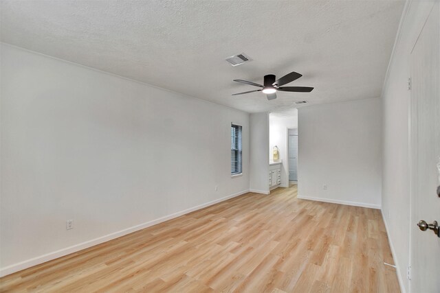 empty room featuring ceiling fan, a textured ceiling, and light wood-type flooring