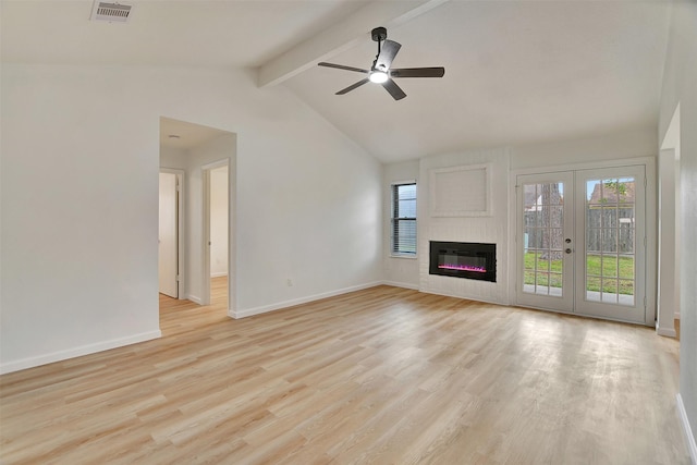 unfurnished living room with ceiling fan, a fireplace, lofted ceiling with beams, and light hardwood / wood-style floors