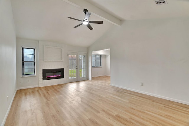 unfurnished living room with beam ceiling, light hardwood / wood-style floors, a brick fireplace, and ceiling fan