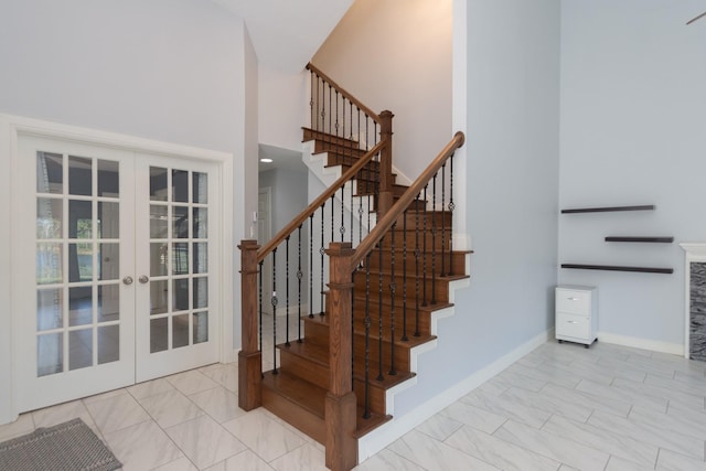 stairway with french doors and a high ceiling