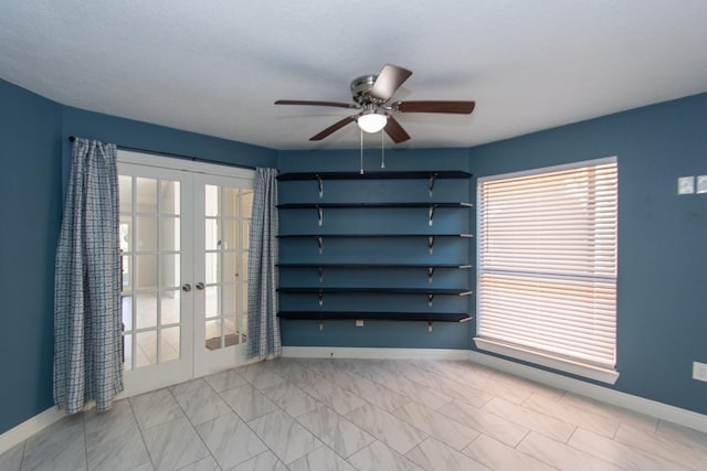 empty room with ceiling fan and french doors