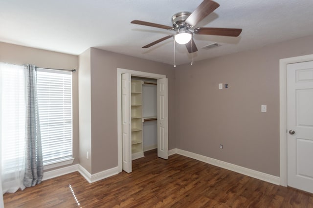 unfurnished bedroom featuring ceiling fan, a closet, and dark wood-type flooring