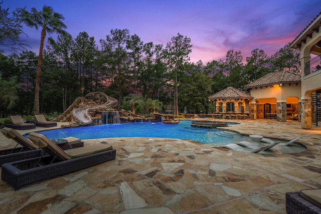 28322 Meadow Frst, Magnolia, TX 77355 - outdoor pool featuring a hot tub, a patio area, view of scattered trees, and a water slide