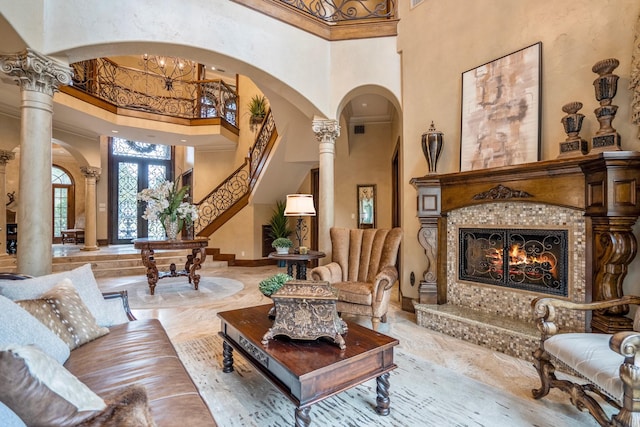 28322 Meadow Frst, Magnolia, TX 77355 - living area with a high ceiling, arched walkways, a tiled fireplace, marble tiled flooring, and stairway