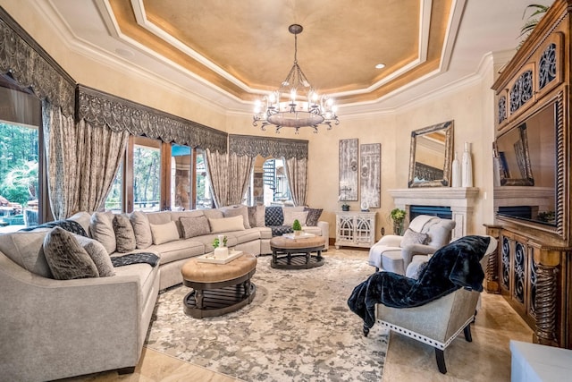 living room featuring an inviting chandelier, a healthy amount of sunlight, crown molding, and a tray ceiling