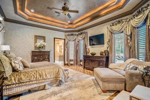 bedroom with light wood-type flooring, a raised ceiling, ceiling fan, and crown molding