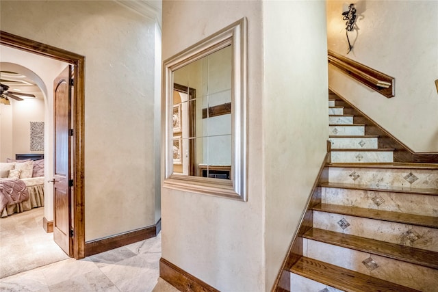 staircase featuring ceiling fan