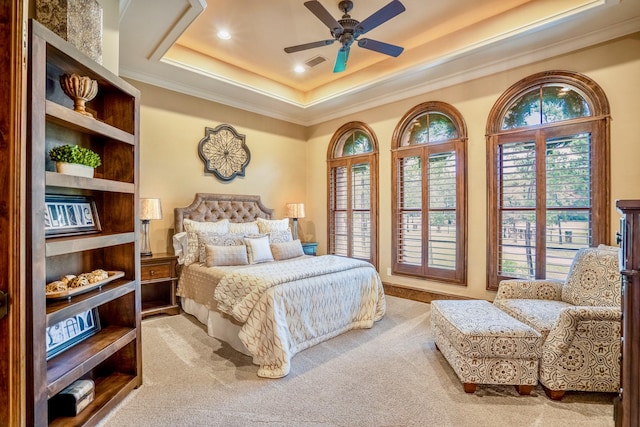 bedroom with a tray ceiling, ceiling fan, light colored carpet, and ornamental molding