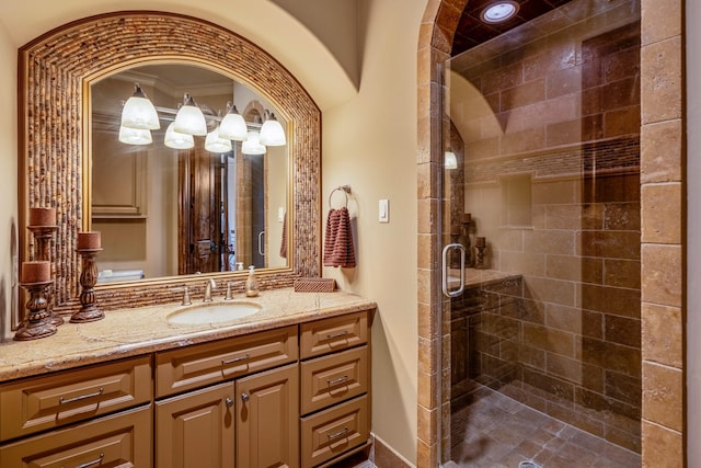 bathroom with crown molding, vanity, and a shower with shower door