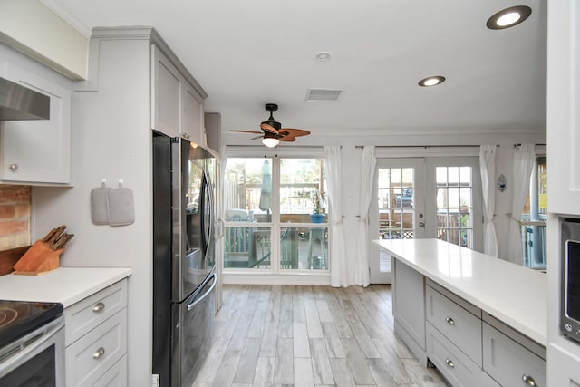 kitchen featuring stainless steel appliances, a healthy amount of sunlight, gray cabinetry, and light hardwood / wood-style floors