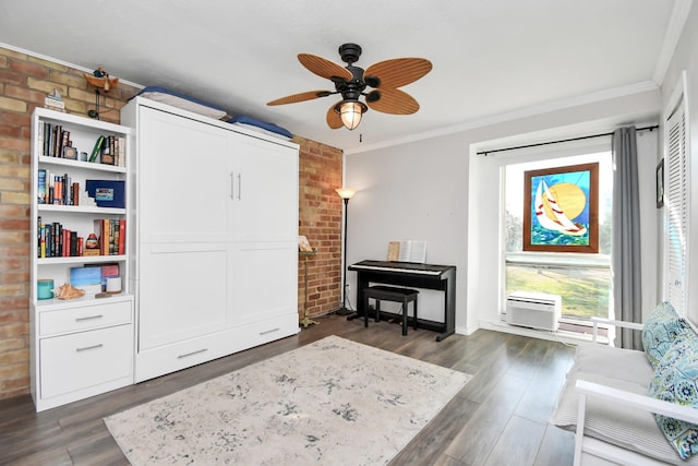 sitting room featuring ceiling fan, brick wall, ornamental molding, and dark hardwood / wood-style floors