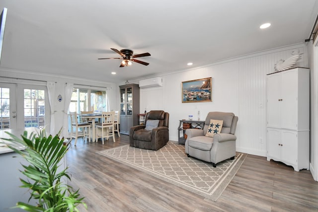 living room with crown molding, ceiling fan, hardwood / wood-style floors, french doors, and an AC wall unit