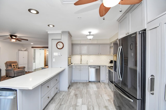 kitchen featuring stainless steel appliances, gray cabinetry, and kitchen peninsula