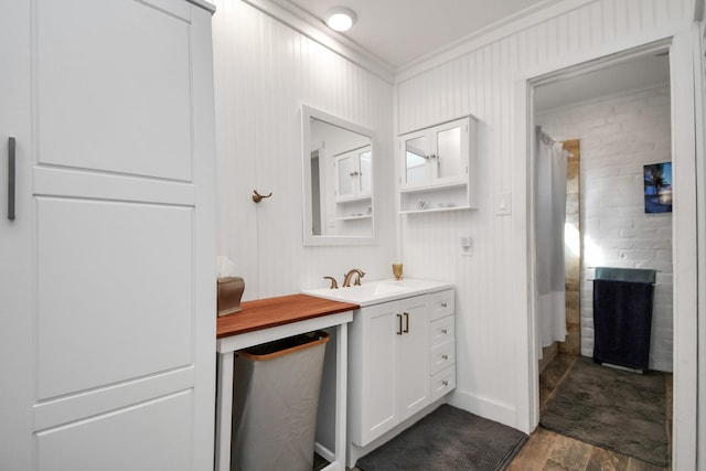 bathroom featuring vanity, hardwood / wood-style floors, a shower with curtain, and ornamental molding