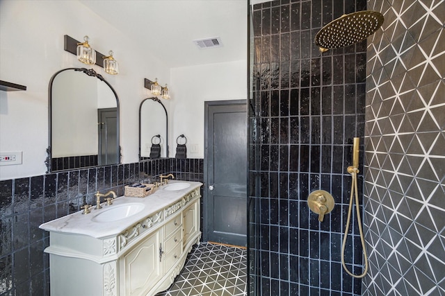 bathroom with tile patterned floors, vanity, tile walls, and tiled shower