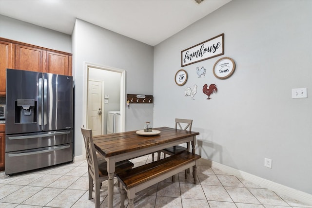 tiled dining area with separate washer and dryer