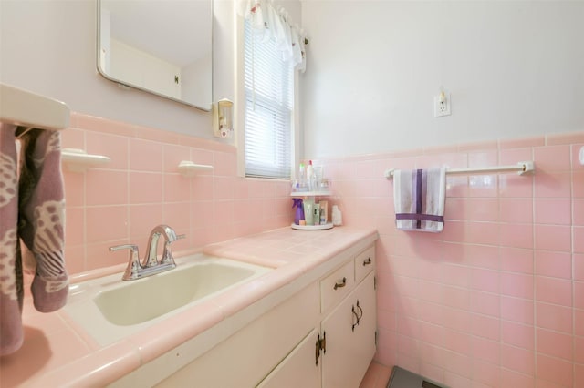 bathroom featuring vanity and tile walls