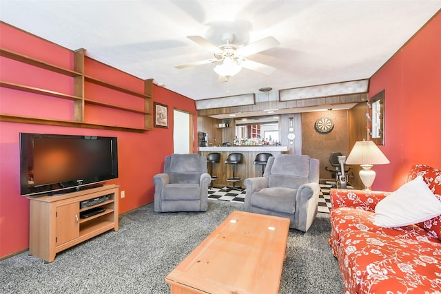 carpeted living room featuring bar area and ceiling fan