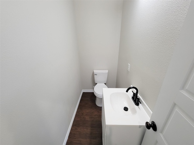 bathroom featuring wood-type flooring, toilet, and sink