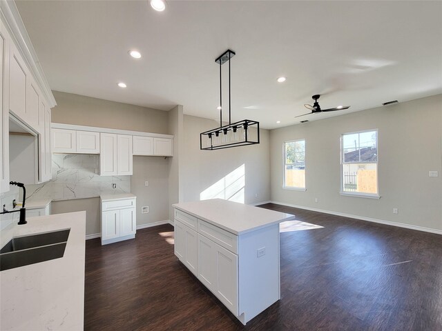 kitchen featuring white cabinetry, a kitchen island, pendant lighting, and ceiling fan