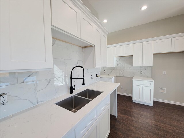 kitchen featuring white cabinets, sink, decorative backsplash, light stone countertops, and dark hardwood / wood-style flooring