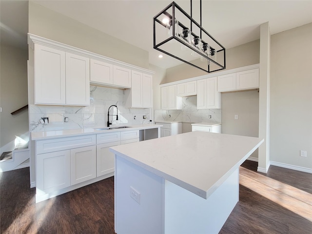 kitchen featuring a center island, backsplash, sink, dark hardwood / wood-style flooring, and white cabinetry