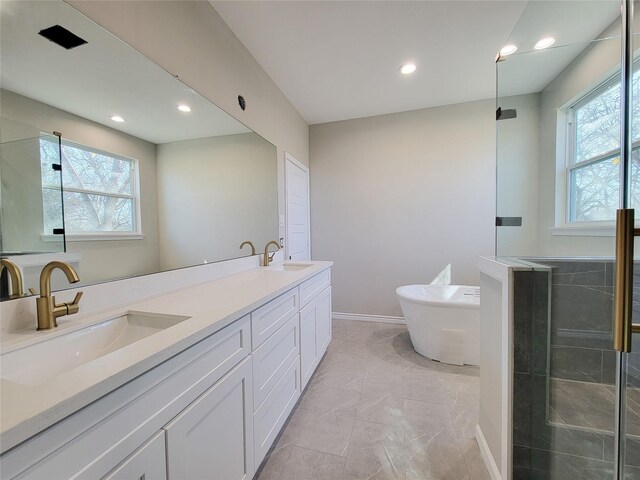 bathroom featuring vanity and independent shower and bath