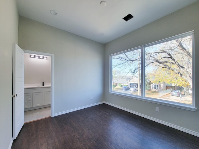 unfurnished bedroom with sink and dark wood-type flooring