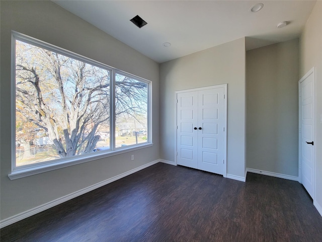 unfurnished bedroom featuring dark hardwood / wood-style flooring and a closet