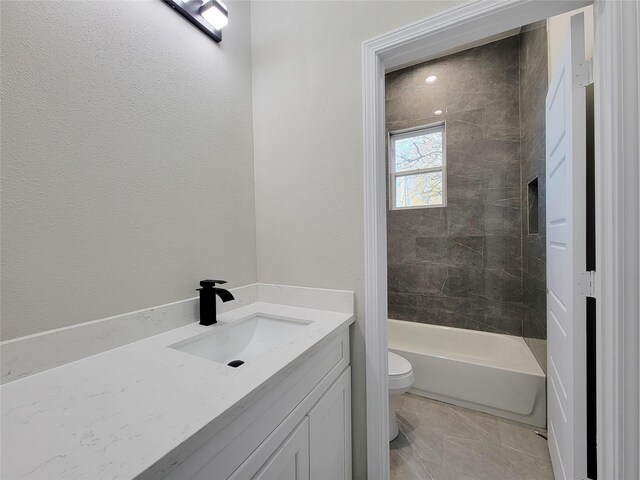 full bathroom with vanity, tiled shower / bath combo, and toilet