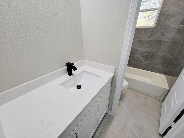 full bathroom featuring tile patterned flooring, vanity, toilet, and tiled shower / bath