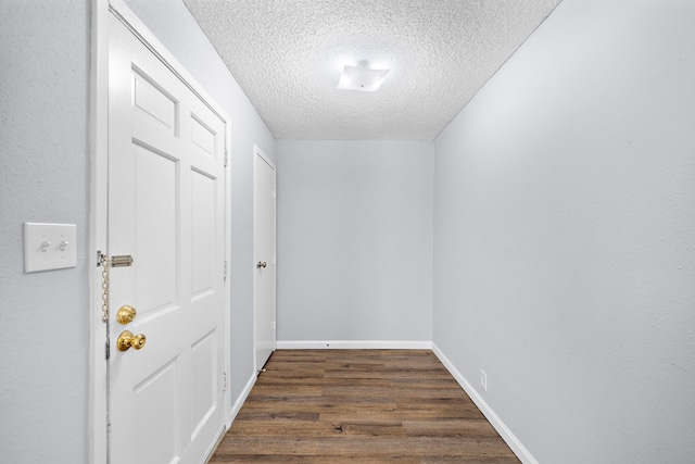 corridor featuring dark hardwood / wood-style floors and a textured ceiling