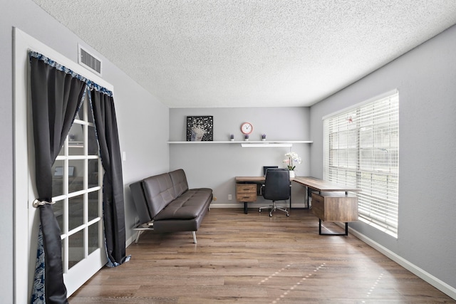 office featuring hardwood / wood-style flooring, a wealth of natural light, and a textured ceiling