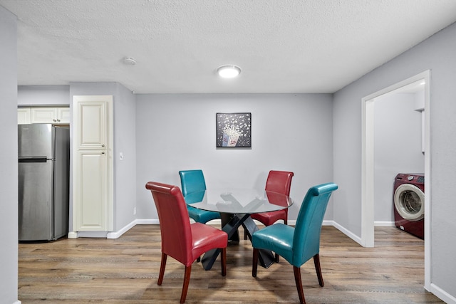 dining area featuring hardwood / wood-style flooring, washer / dryer, and a textured ceiling