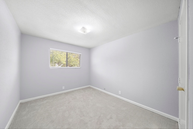 unfurnished room with a textured ceiling and carpet