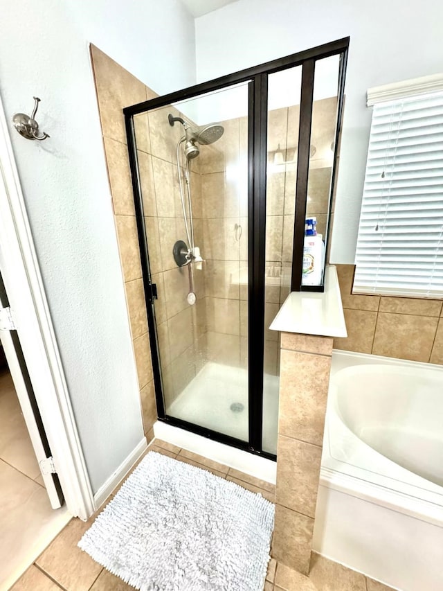 bathroom with tile patterned flooring and shower with separate bathtub