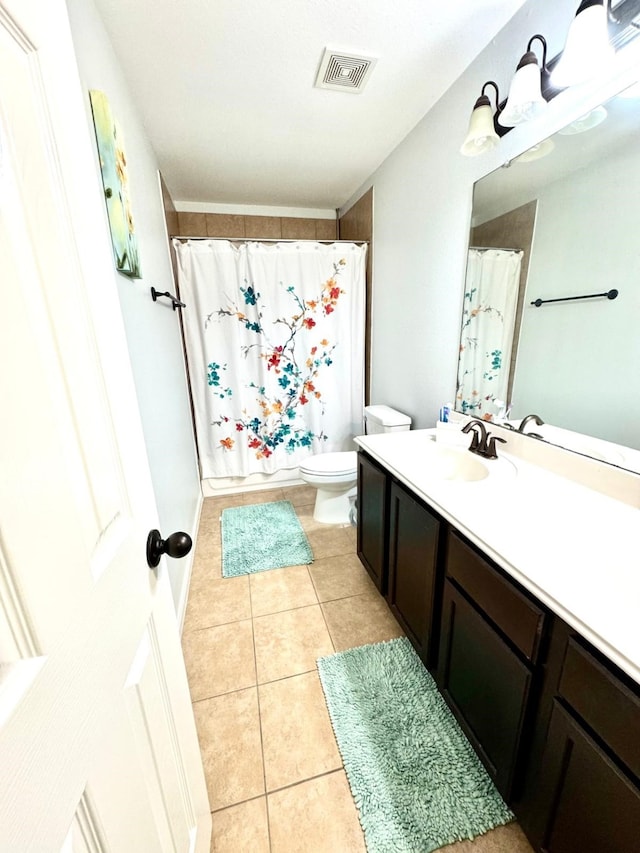 bathroom featuring tile patterned floors, curtained shower, vanity, and toilet