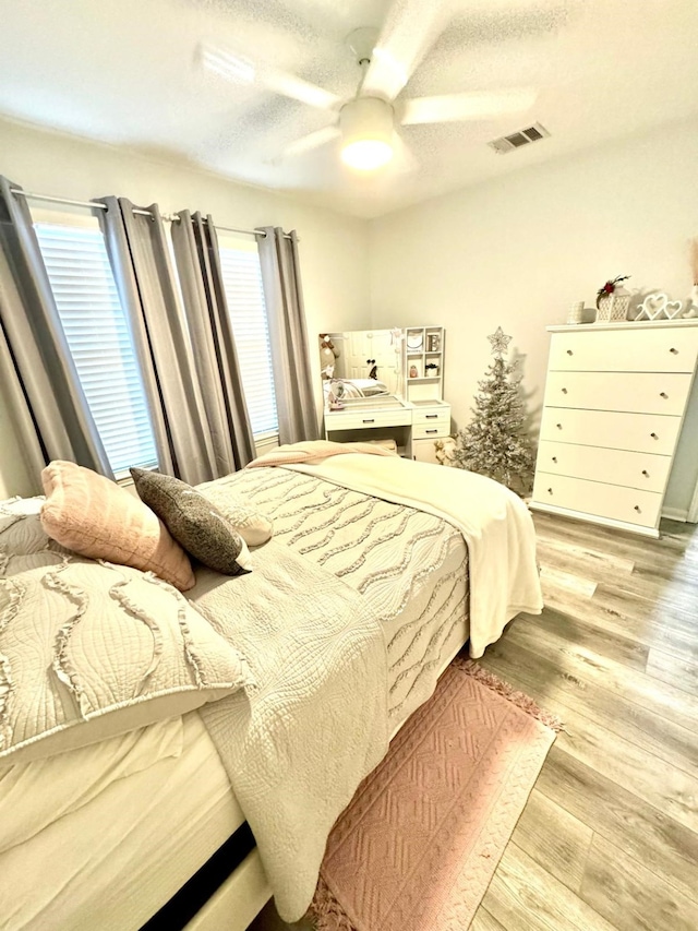 bedroom with light hardwood / wood-style floors and ceiling fan