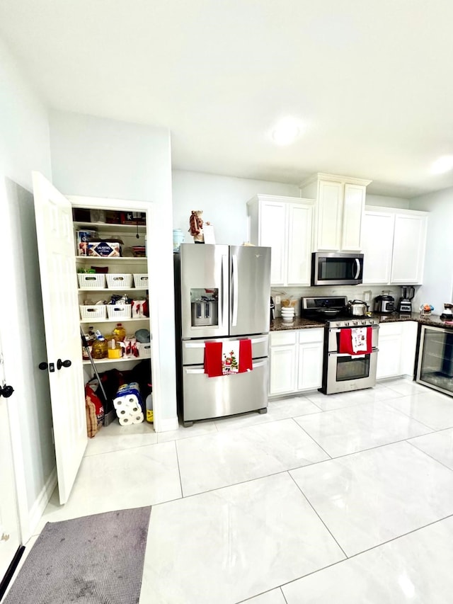 kitchen featuring tasteful backsplash, white cabinetry, and stainless steel appliances